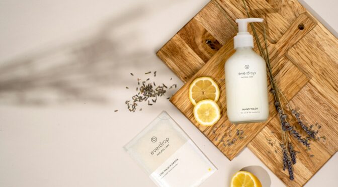 a wooden cutting board topped with a bottle of lotion